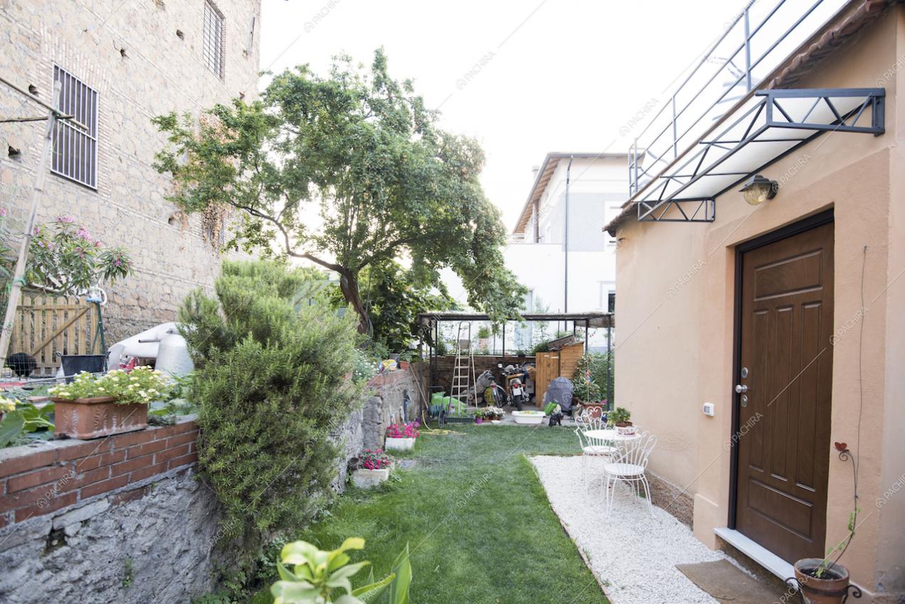 Giardino con veranda e piccolo tavolo in metallo bianco
