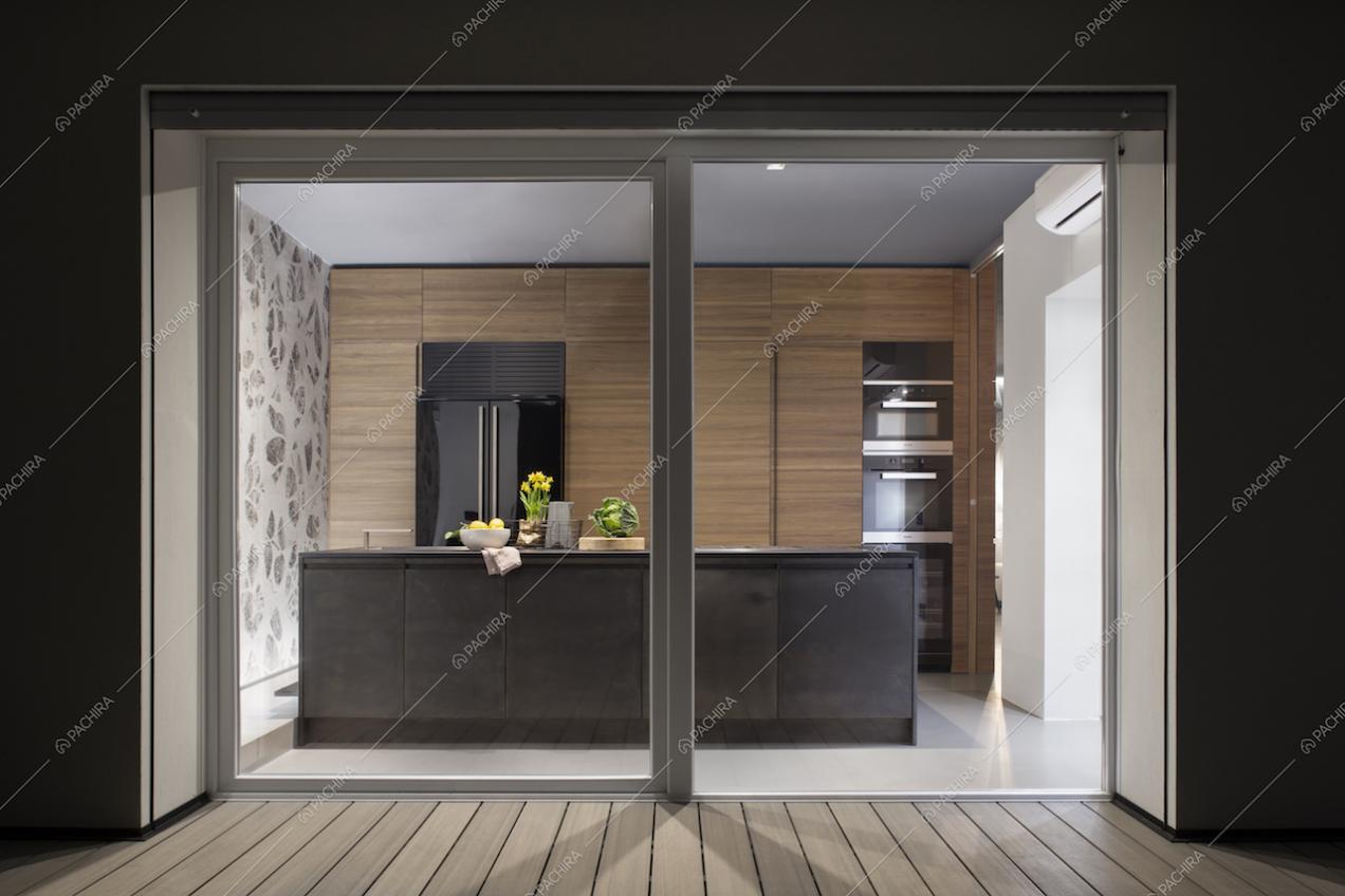 Cucina a vista con vetrate e pavimento in teak