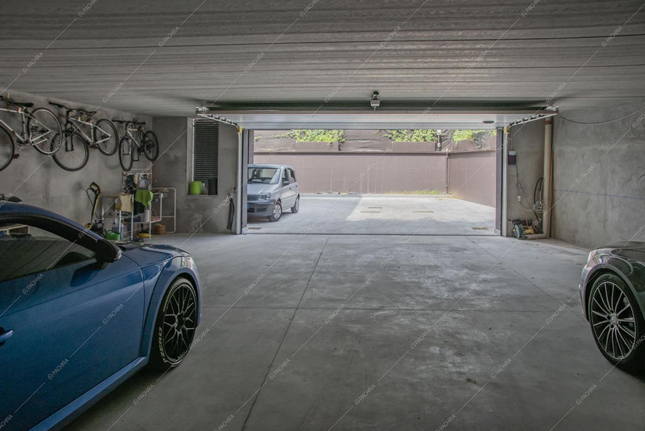 Grande garage con automobili e biciclette appese