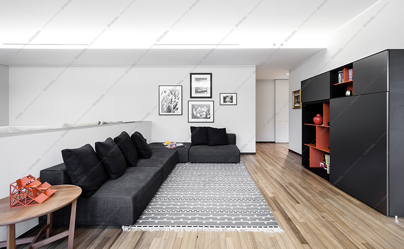 Zona living con divano e libreria neri, tavolino in legno