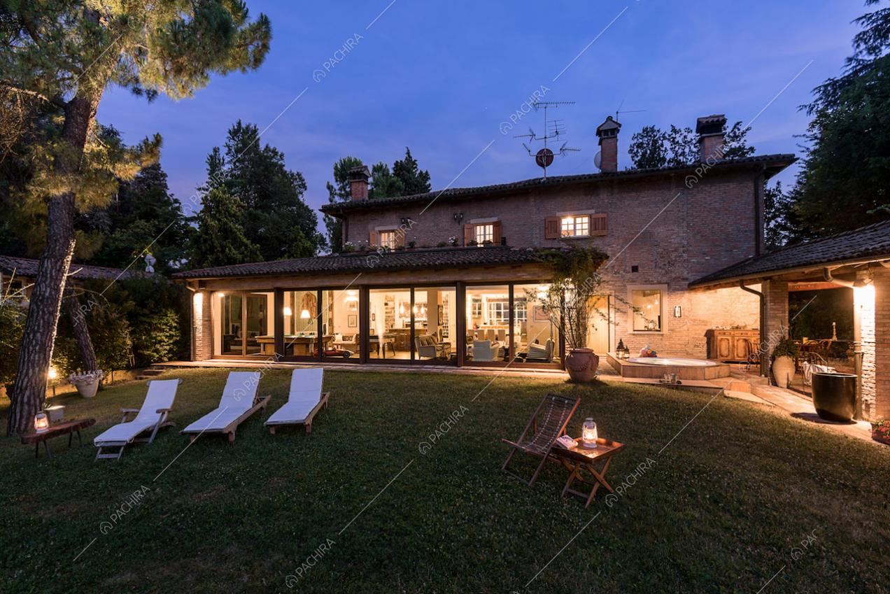 Giardino privato della location con lettini bianchi e vista sugli interni attraverso le vetrate