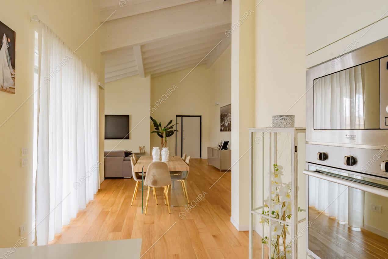 Tavolo da pranzo in legno nella zona living con vetrate e pavimento in parquet