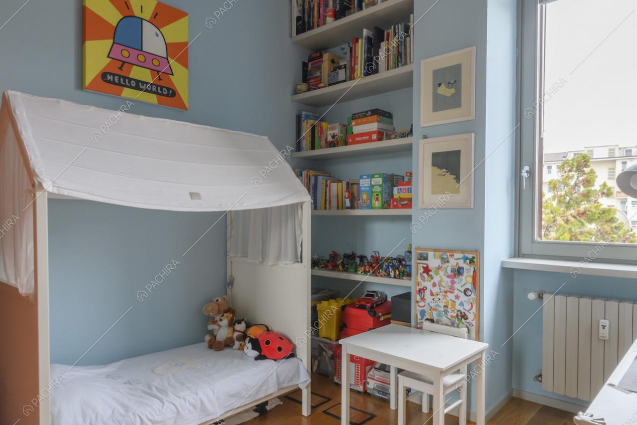 Camera da letto con libreria a muro e lettino a baldacchino