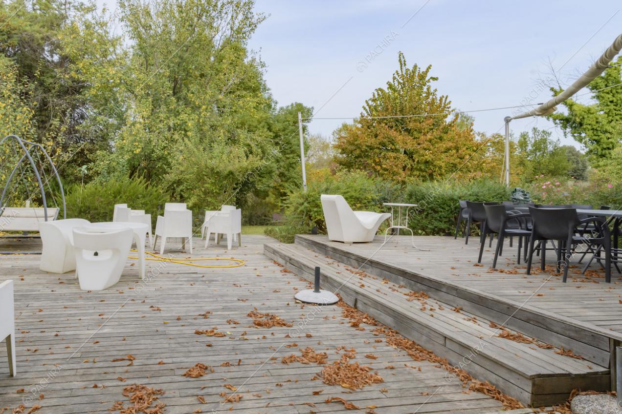 Patio con pavimentazione in legno e sedie da esterni