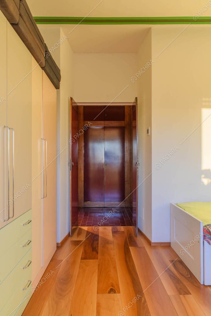 Camera da letto con pavimento in parquet e pareti bianche