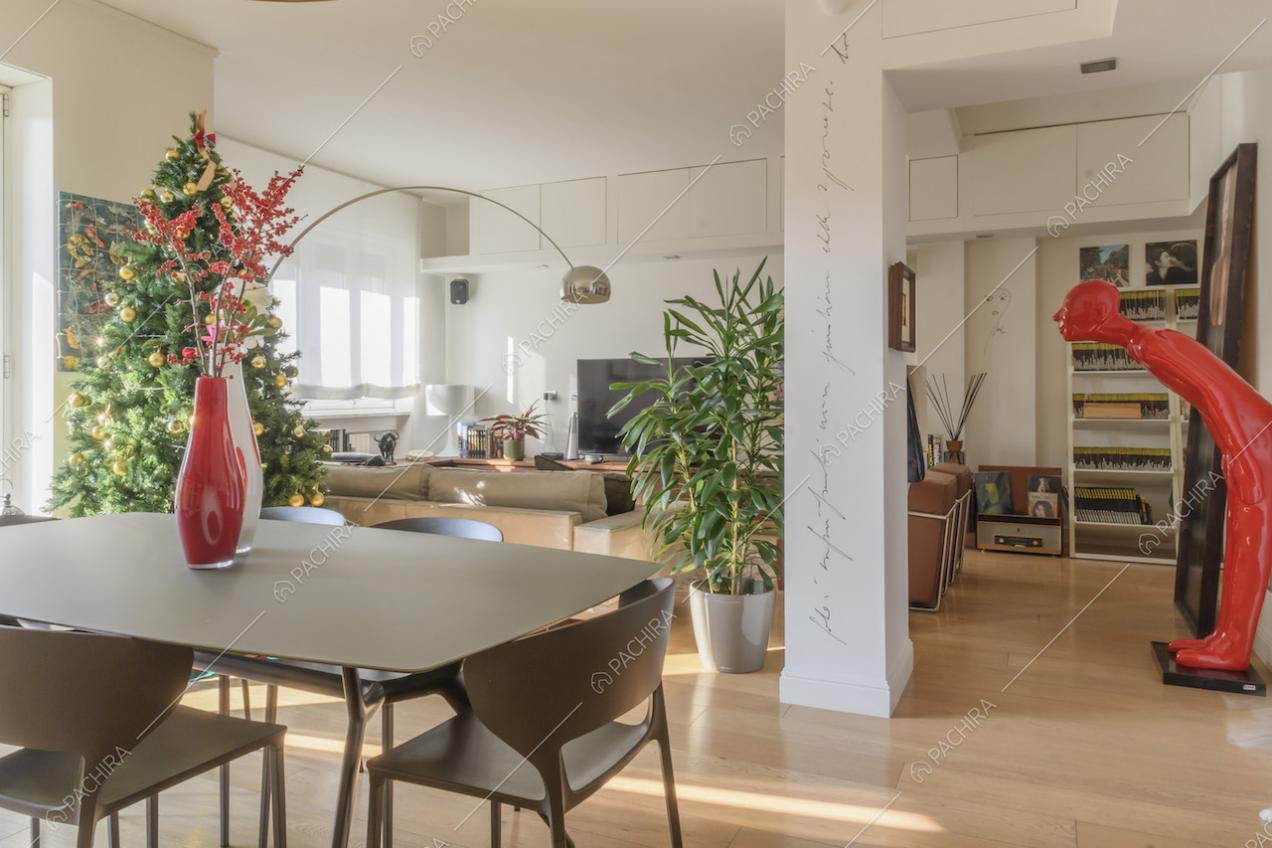 Zona living con colonna bianca e pavimenti in parquet