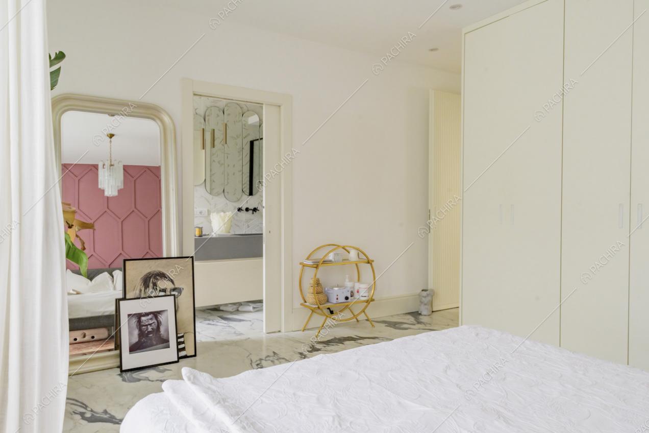 Camera da letto matrimoniale dalle pareti bianche con bagno privato e pavimento in marmo
