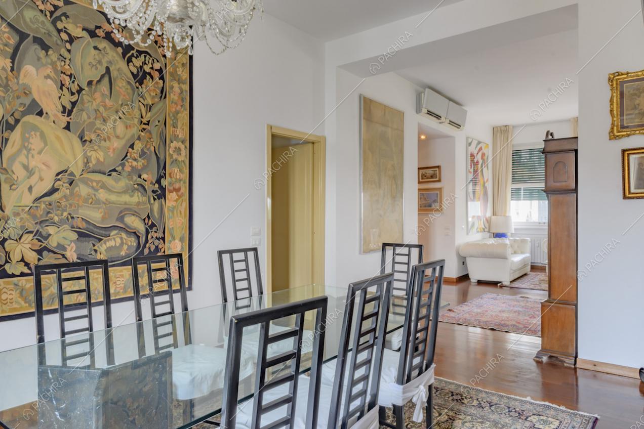 Sedie nere di design nella sala da pranzo con tavolo in vetro e pareti bianche