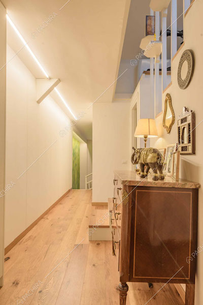 Corridoio con pareti bianche, pavimento in parquet e scale