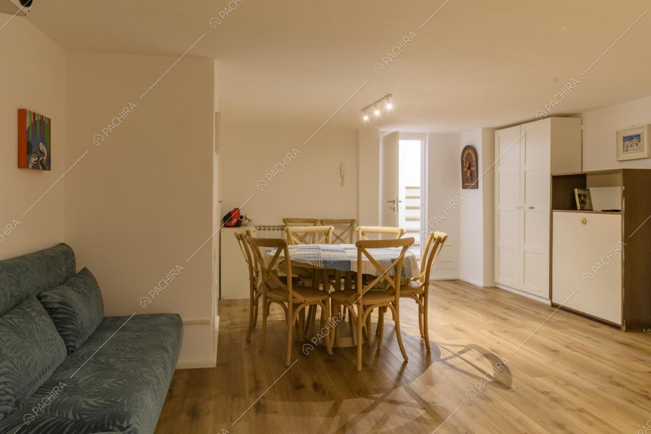 Tavolo da pranzo rotondo con sedie in legno e armadio bianco