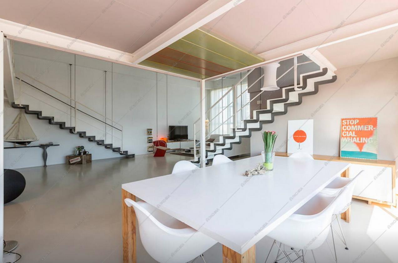 Il tavolo da pranzo e le scale per il secondo livello del loft