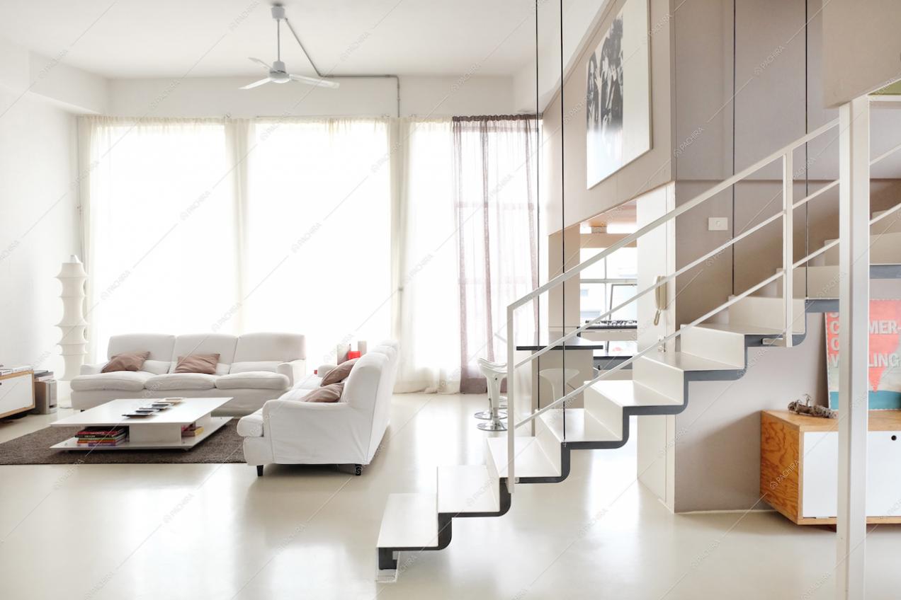 Il salotto con le ampie vetrate del loft total white