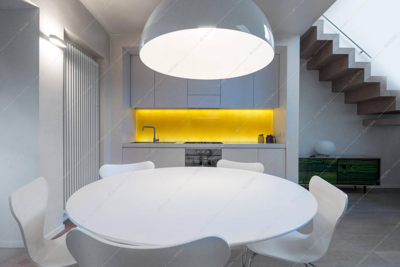 Cucina a vista e tavolo da pranzo bianco