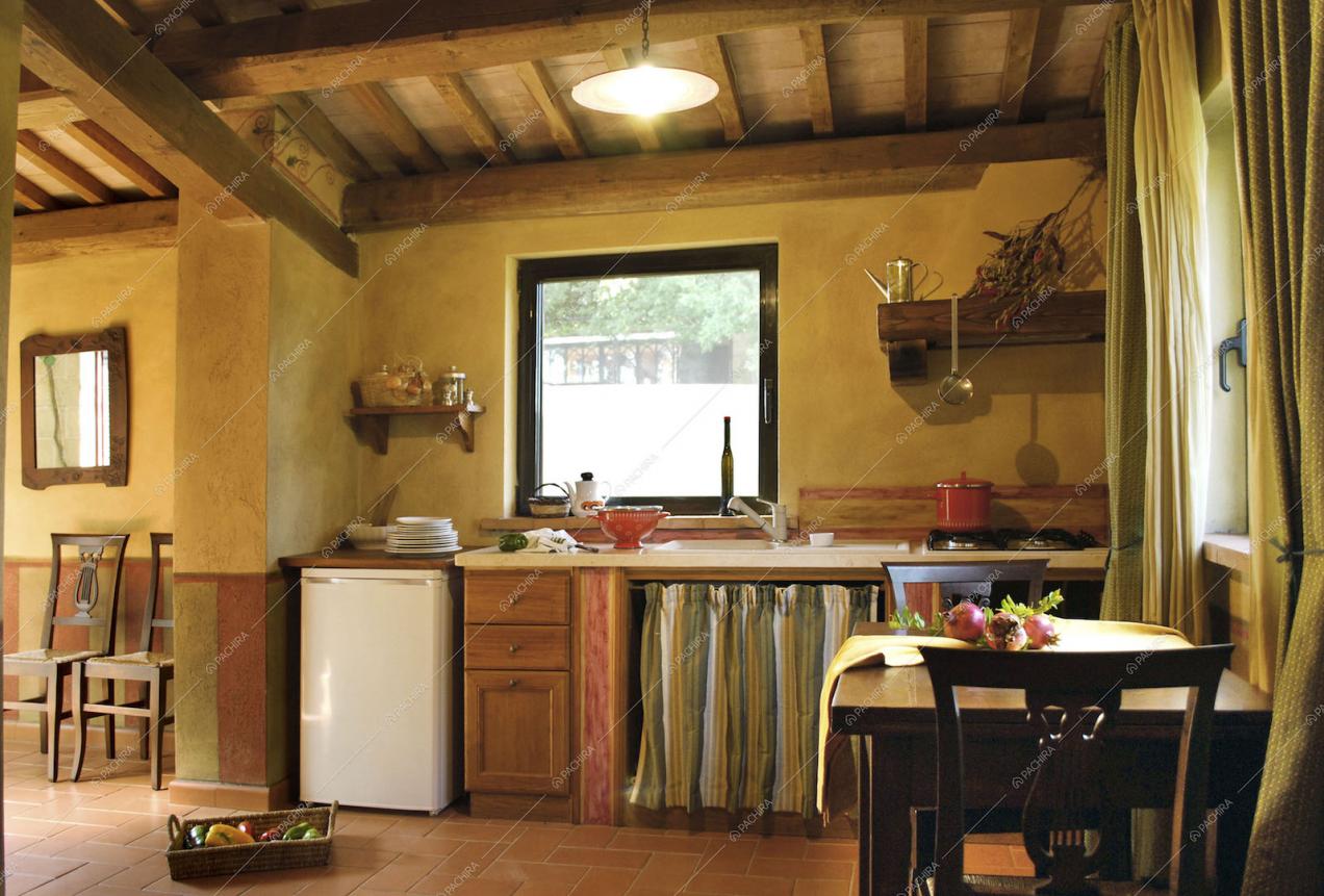 Cucina a parete con soffitto con travi a vista