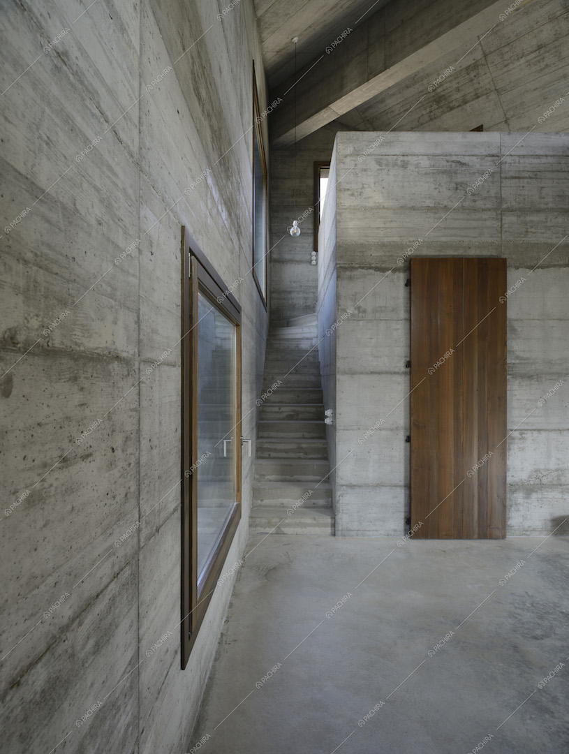 Scale che portano al piano superiore e porta in legno, inquadrati dalla zona soggiorno