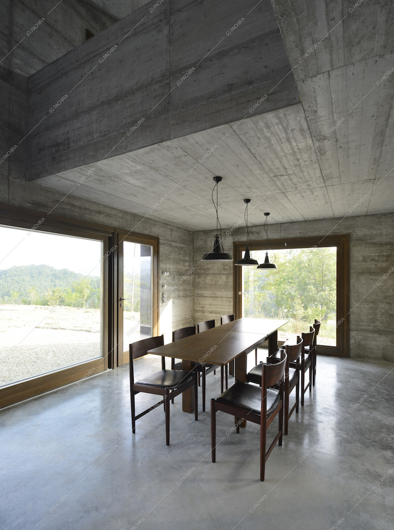 Zona pranzo con tavolo in legno da otto posti e vetrate