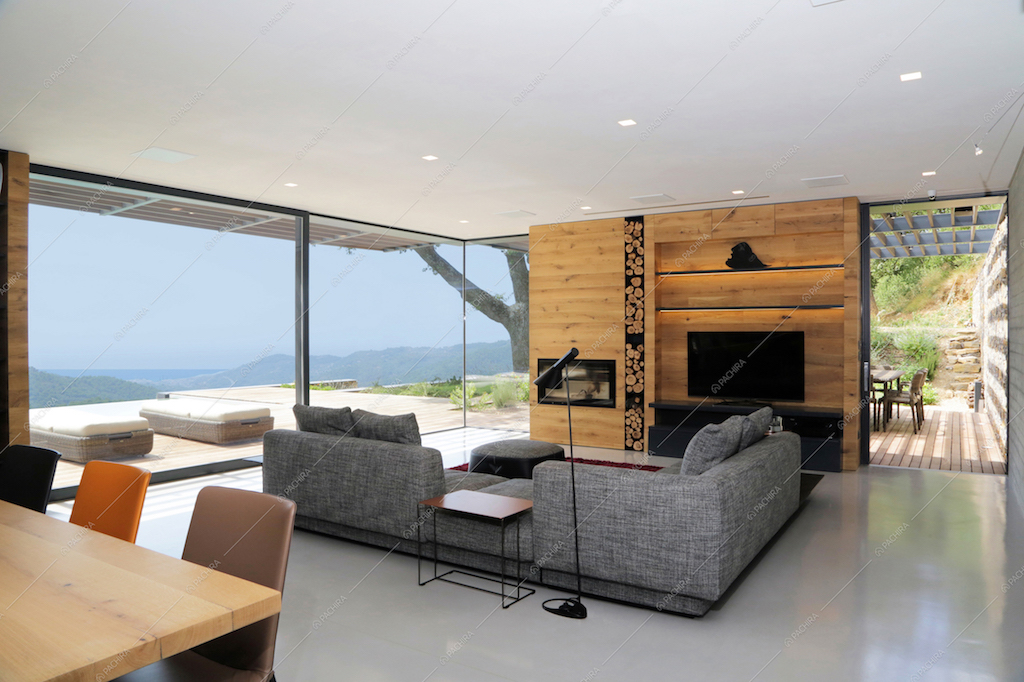 Il living contemporaneo con ampie vetrate e camino