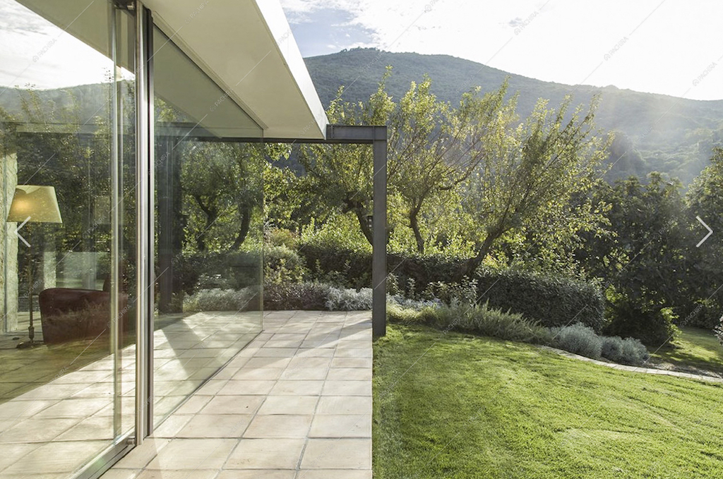 Il rigoglioso giardino e le vetrate della villa