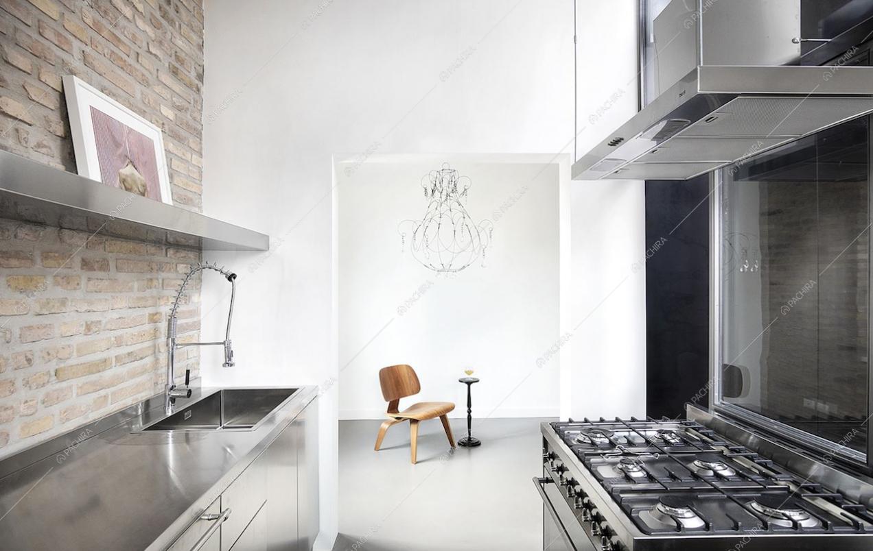 Cucina con fornelli a gas e parete in mattoni