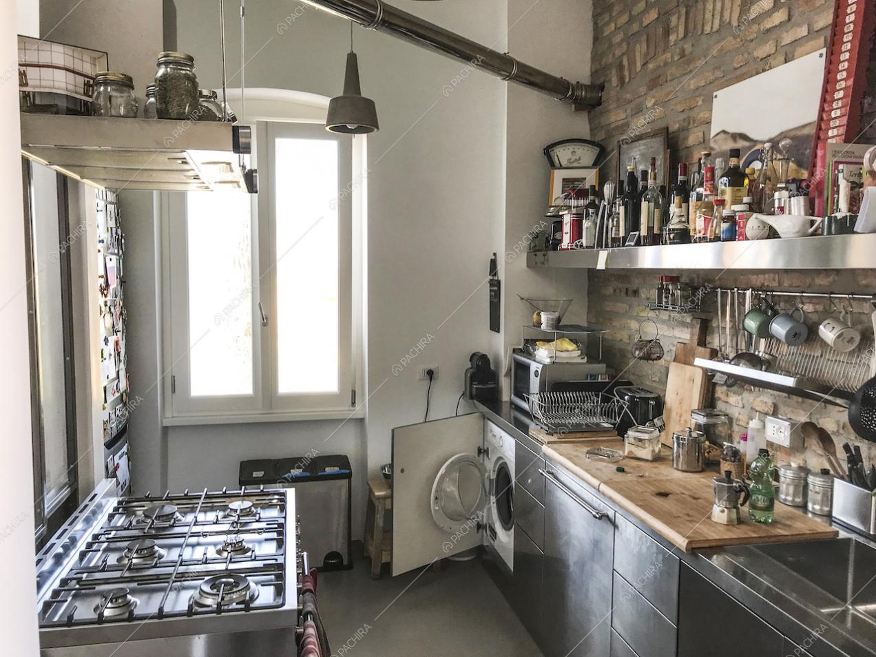 Cucina a parete con fornelli a gas e muro in mattoncini