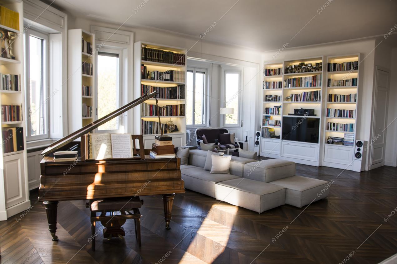 Il salotto della Location Lime: pianoforte, librerie e divani