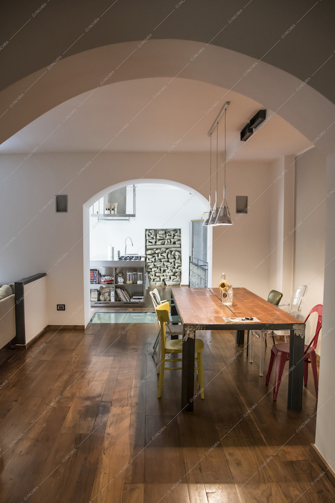 Dalle volte ad arco della Location Carota si intravede la sala da pranzo e la cucina