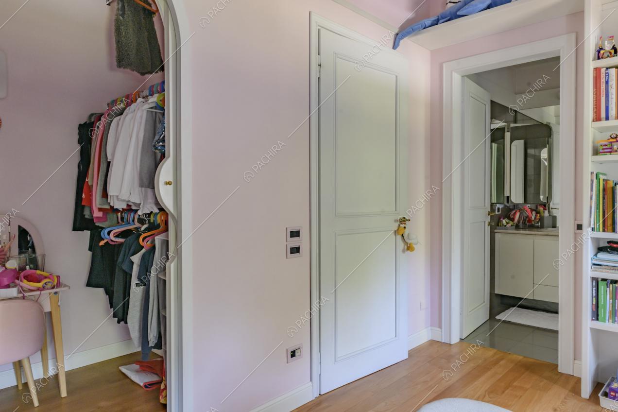 Cabina armadio e bagno privato nella camera da letto dei bambini dalle pareti rosa