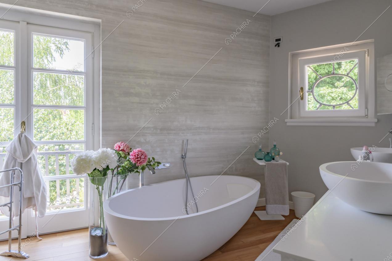 Bagno con vasca, pavimento in parquet e porta-finestra