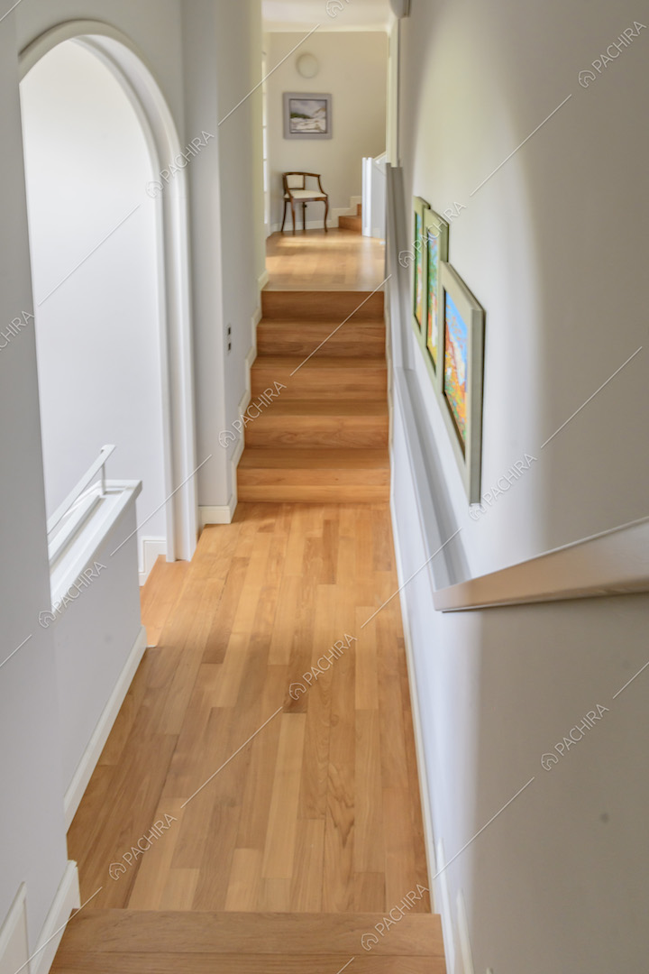 Corridoio con doppia scalinata con pavimento in parquet e arco a volta per accedere alle scale che portano al piano inferiore