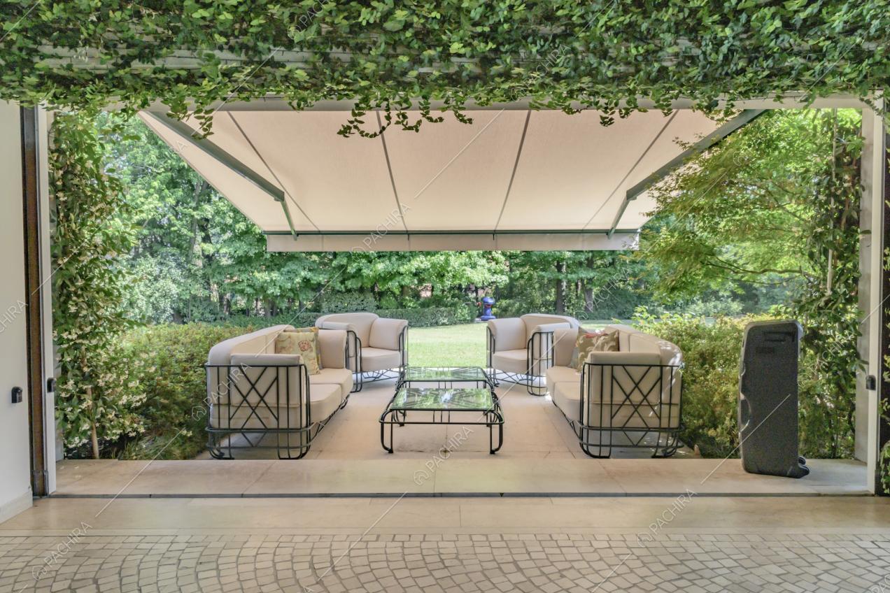 Dalla veranda vista sui divani bianchi coperti da una grande tenda bianca