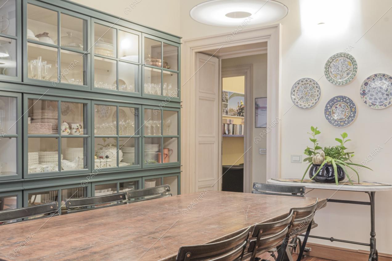 Tavolino vintage, credenza e piatti decorativi appesi alla parete