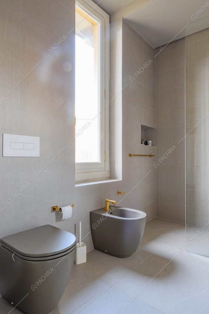 Sanitari grigi nel luminoso bagno con grande box doccia