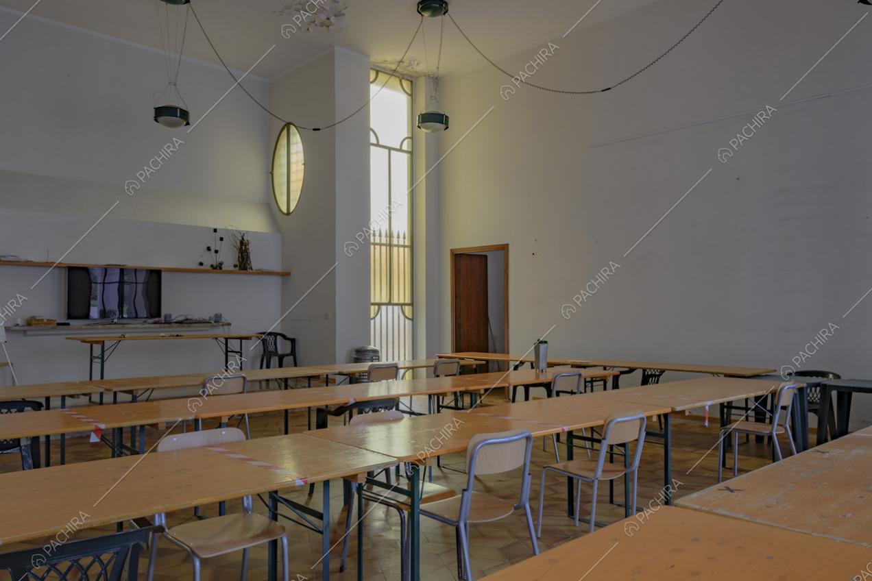 Lunghi tavoli in legno chiaro con sedie da scuola