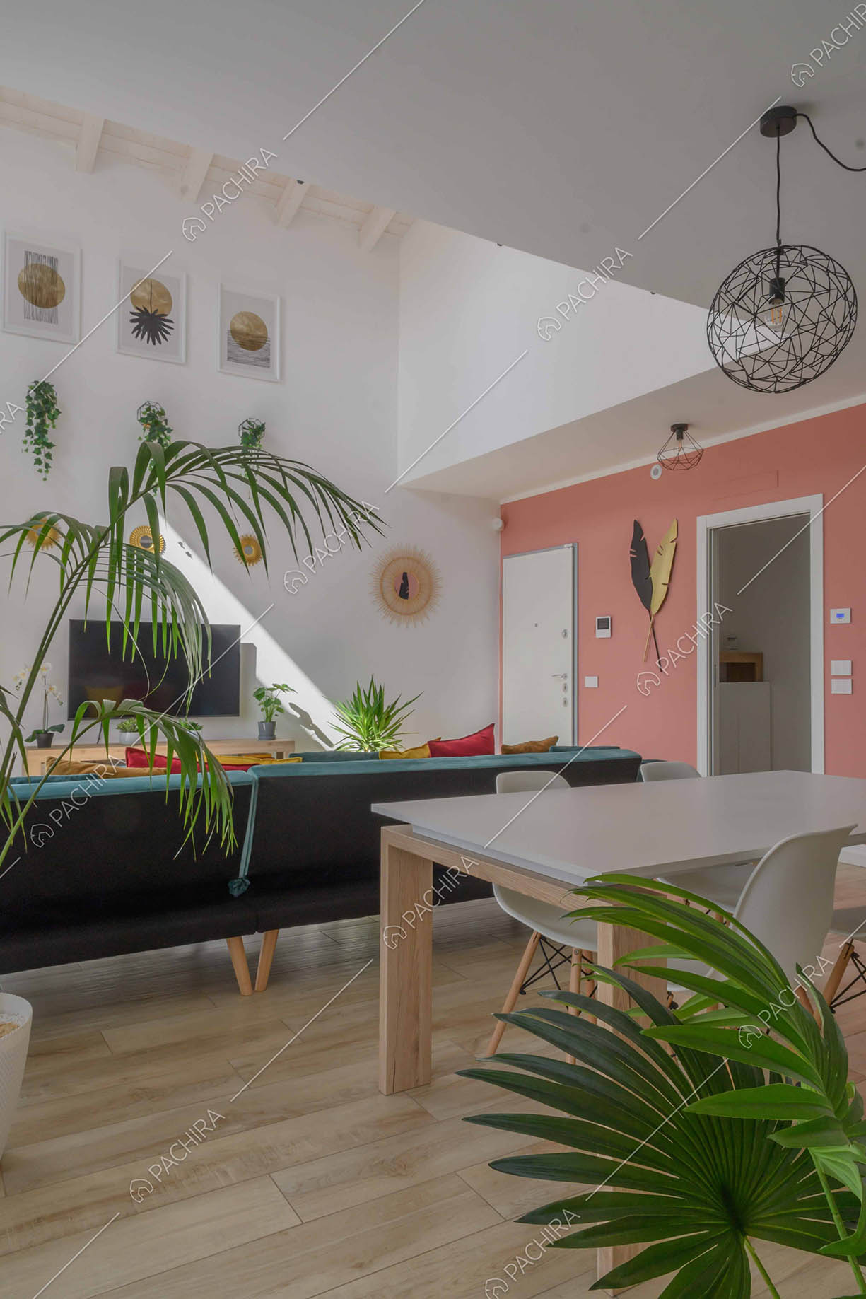 Tavolo da pranzo bianco nella sala con pavimento in parquet e divano in velluto