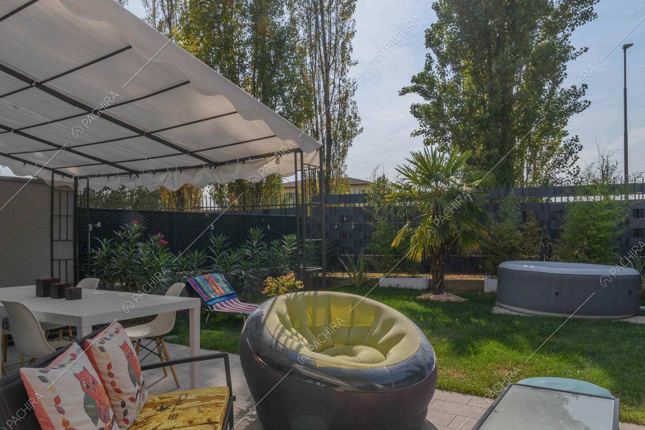 Giardino con idromassaggio, divano, pouf e tavolo bianco