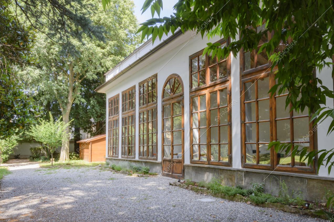 Esterni della limonaia con ampie finestre e immersa nel giardino