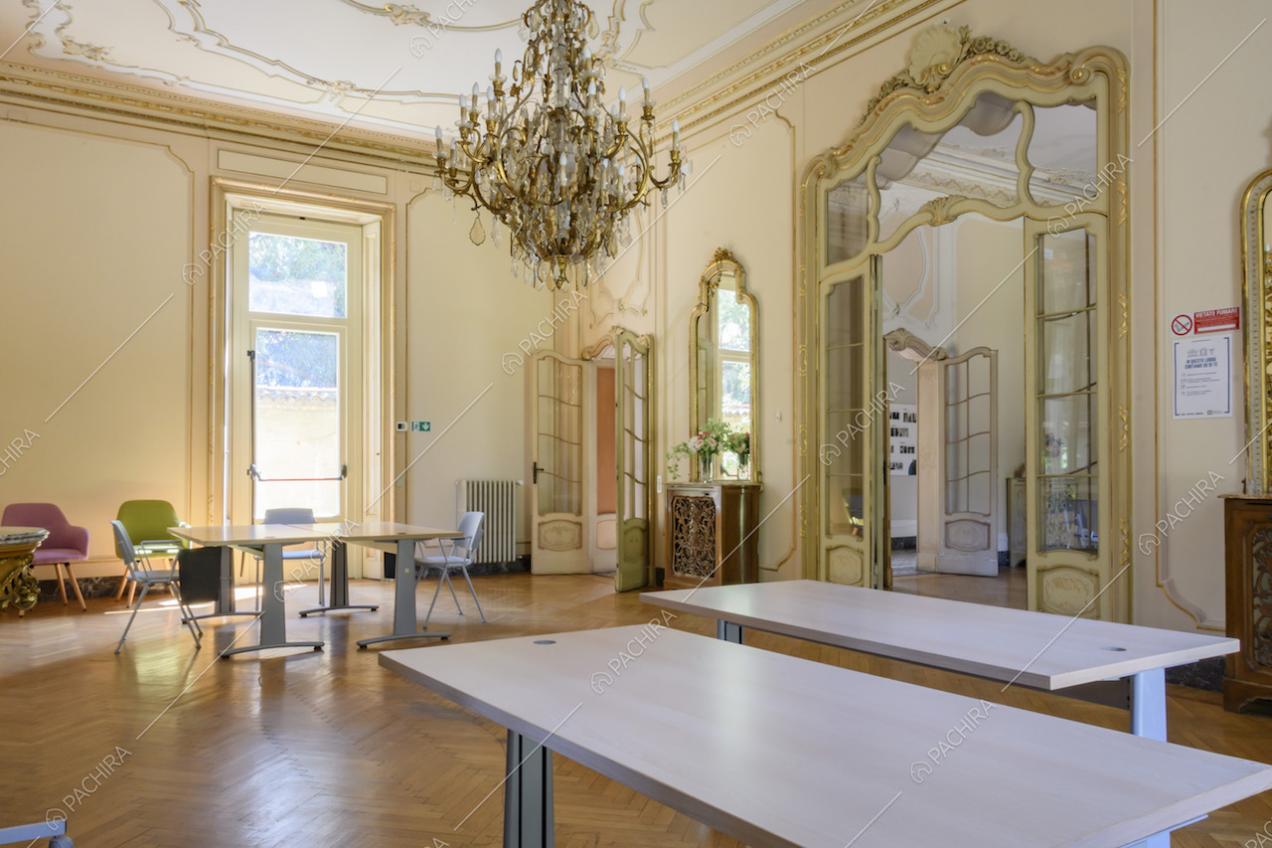 Ampio salone in stile classico sui toni del giallo, pavimento in parquet a spina di pesce e coprifili lavorati