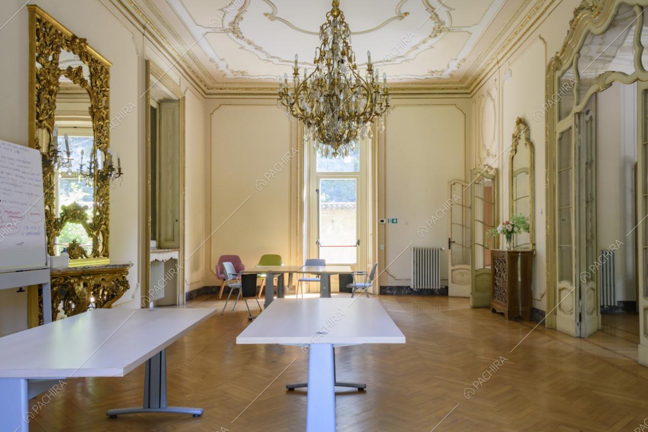 Salone con lampadario antico, pareti e soffitto con boiserie e porte in vetro e legno lavorato