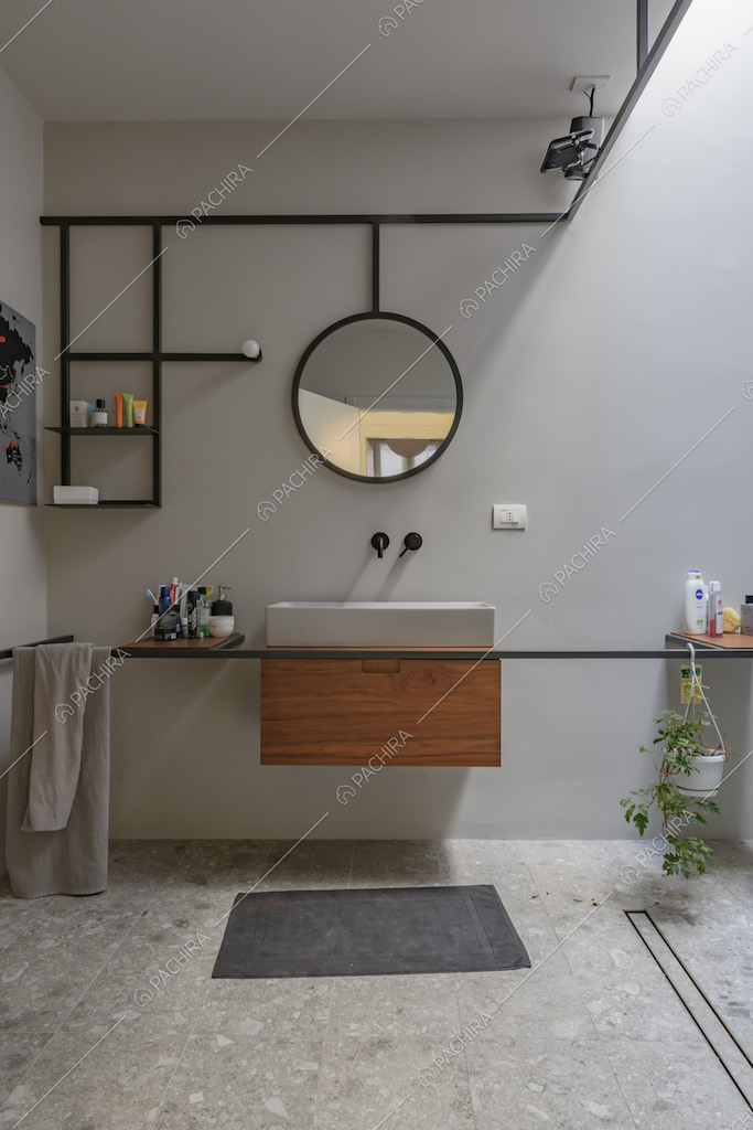 Mobile bagno sospeso in legno e ripiani di design nel bagno dalle pareti bianche