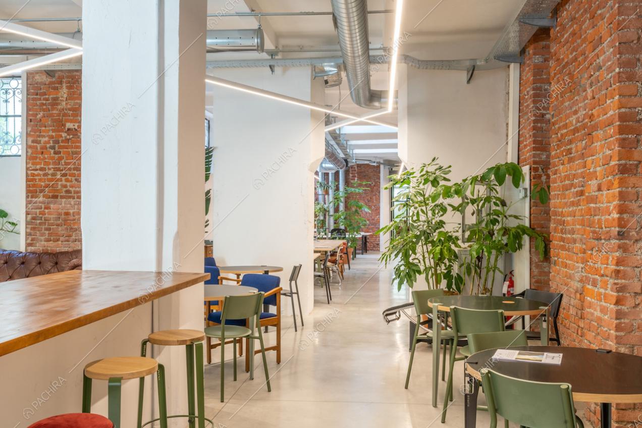 Visuale sull'open space con bancone in legno e pareti con mattoni a vista