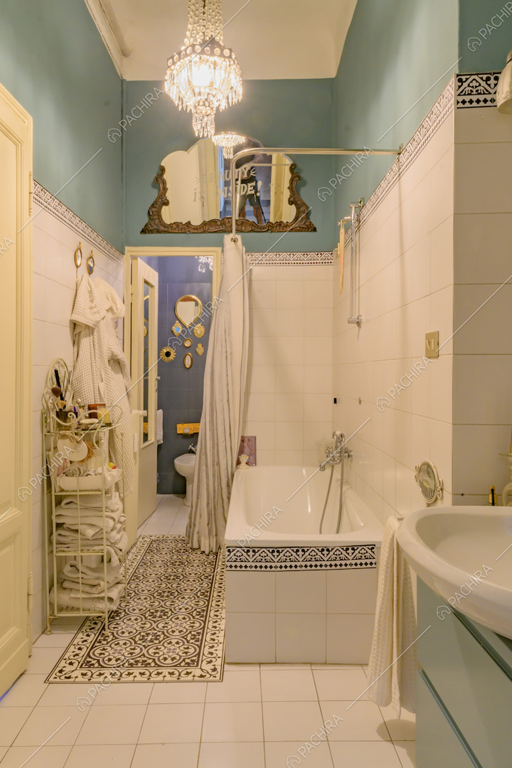 Bagno con pavimento e pareti a piastrelle bianche, vasca da bagno e pareti azzurre