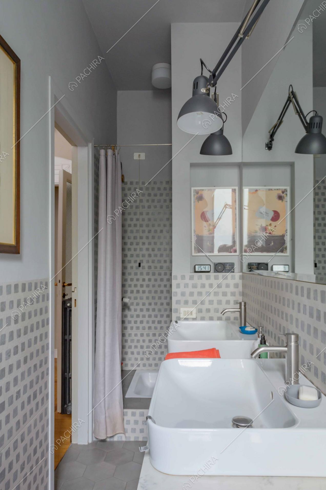 Bagno dalle naunces grigie con doppio lavandino