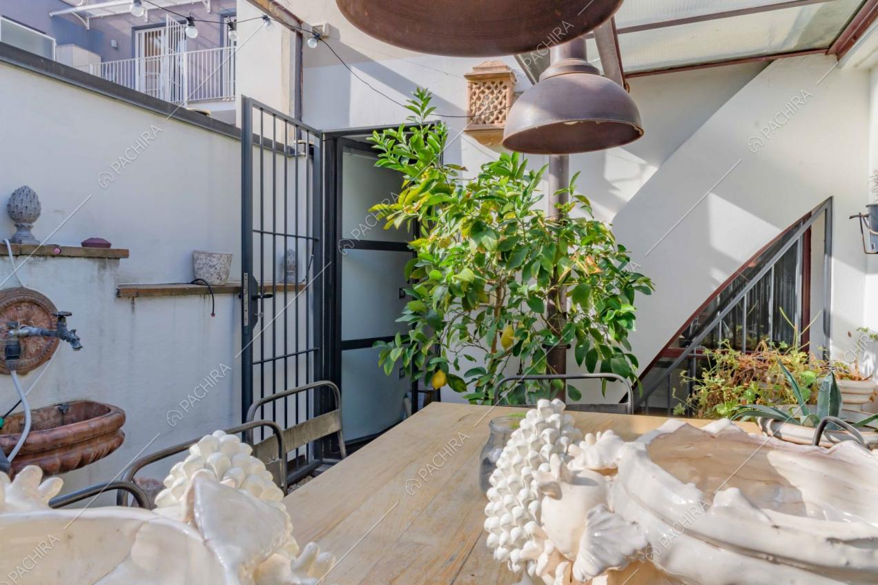 Tavolo da pranzo in legno sulla terrazza con pareti bianche