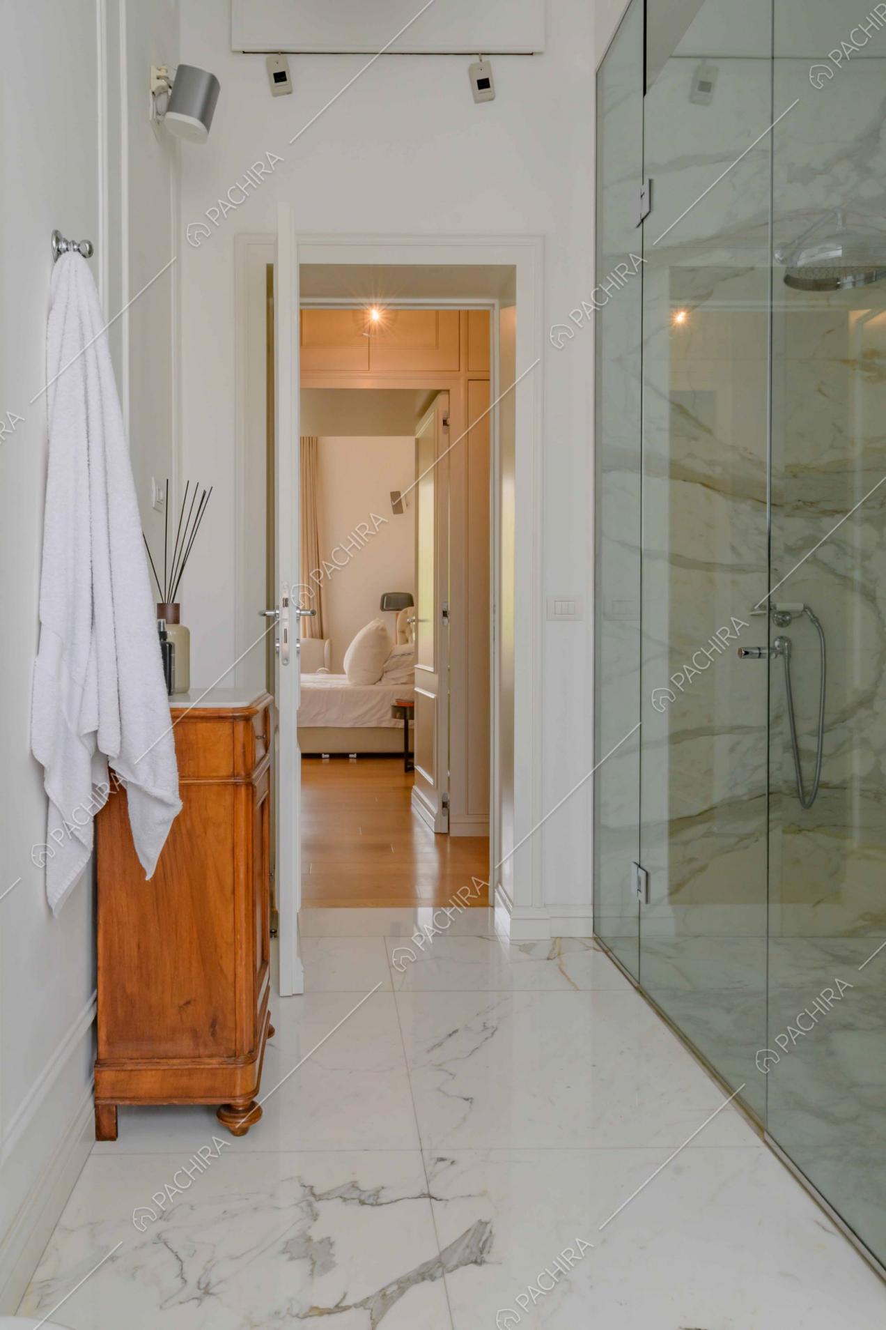 Bagno privato della camera da letto matrimoniale con pavimento in marmo e box doccia
