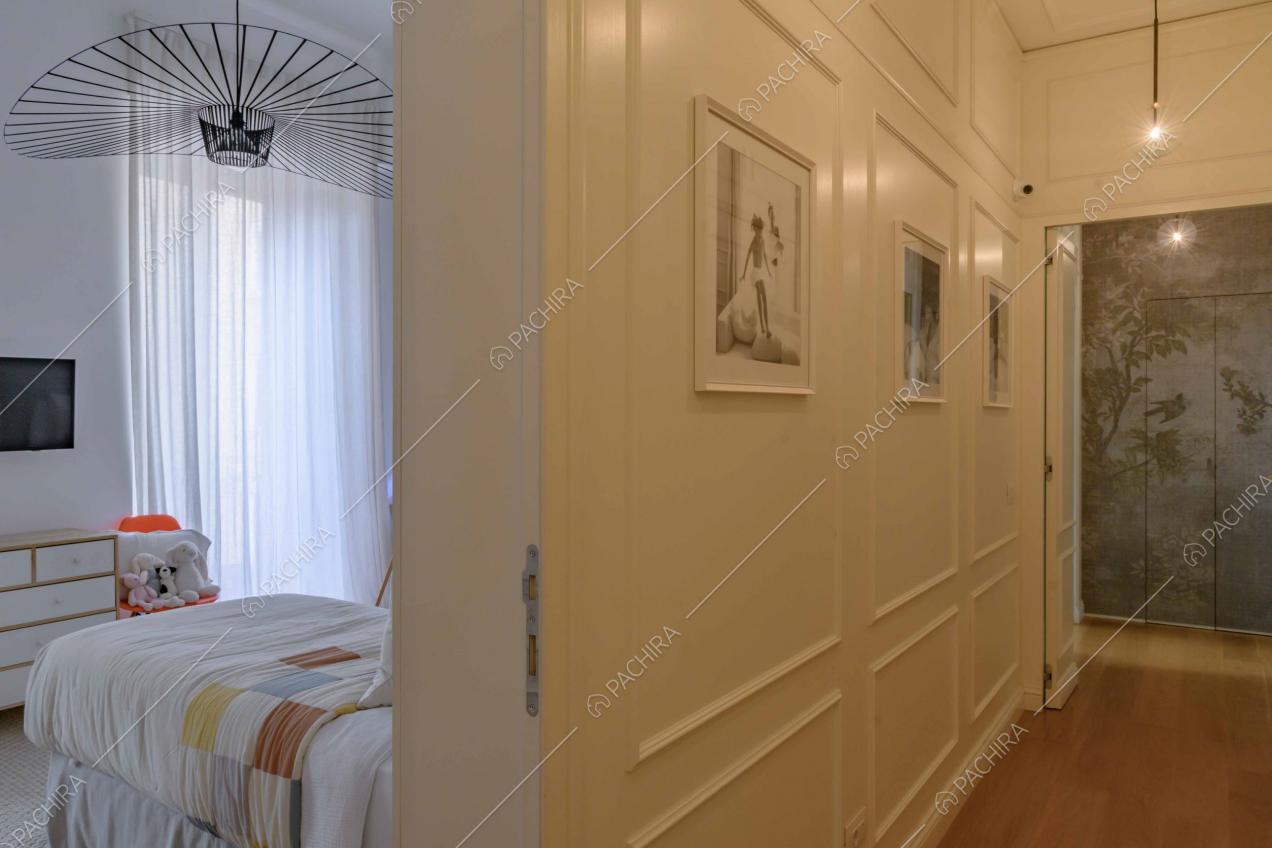 Dal corridoio con boiserie alle pareti vista sulla camera da bambini