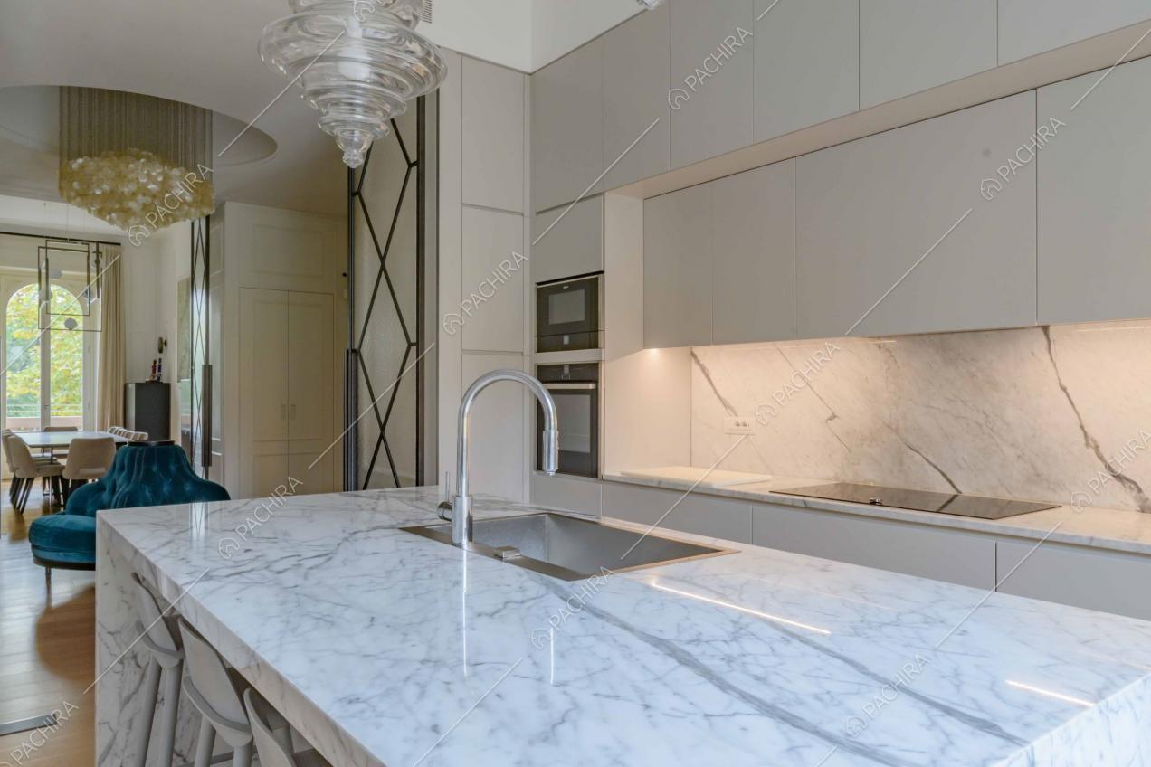 Dall'isola della cucina con sgabelli vista sul soggiorno con tavolo da pranzo