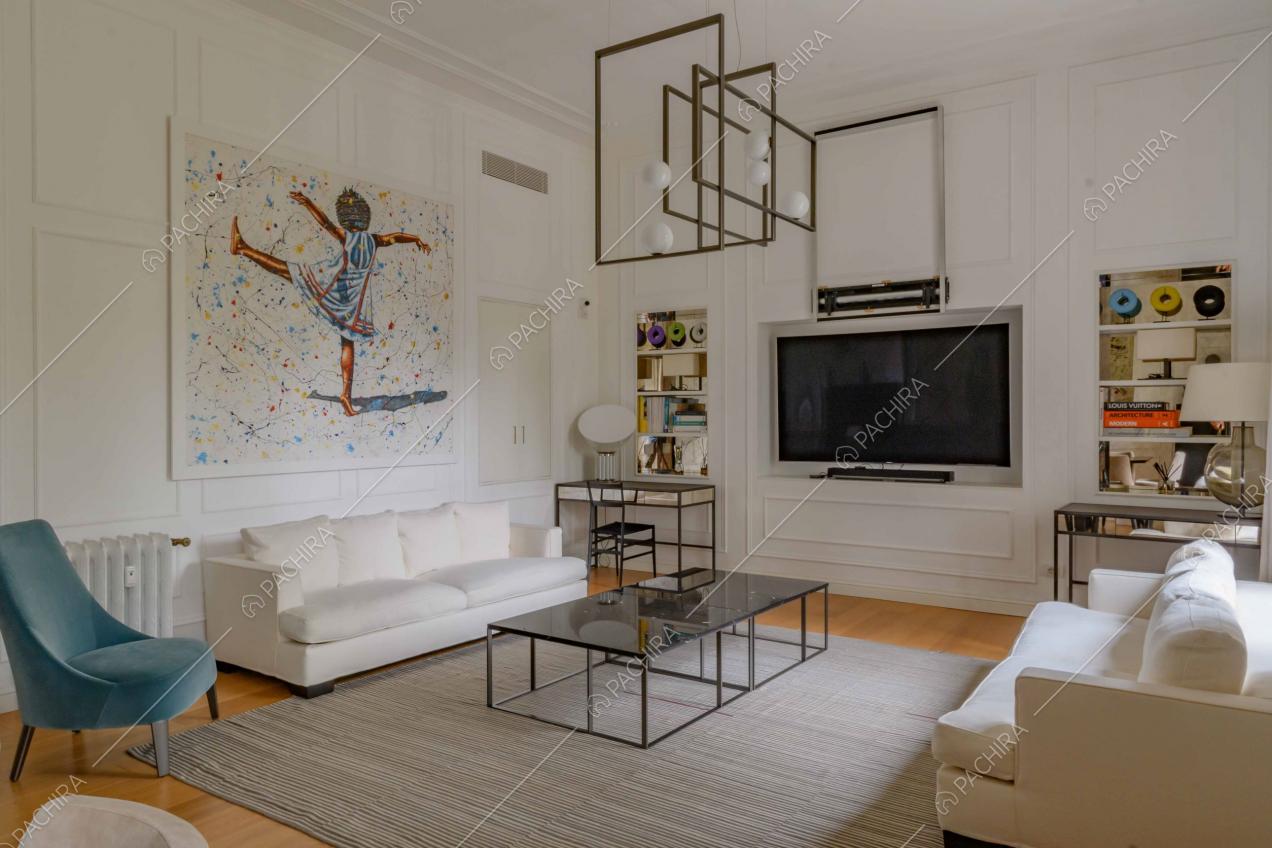 Salotto con elementi di design, pavimento in parquet e boiserie sulle pareti e sul soffitto