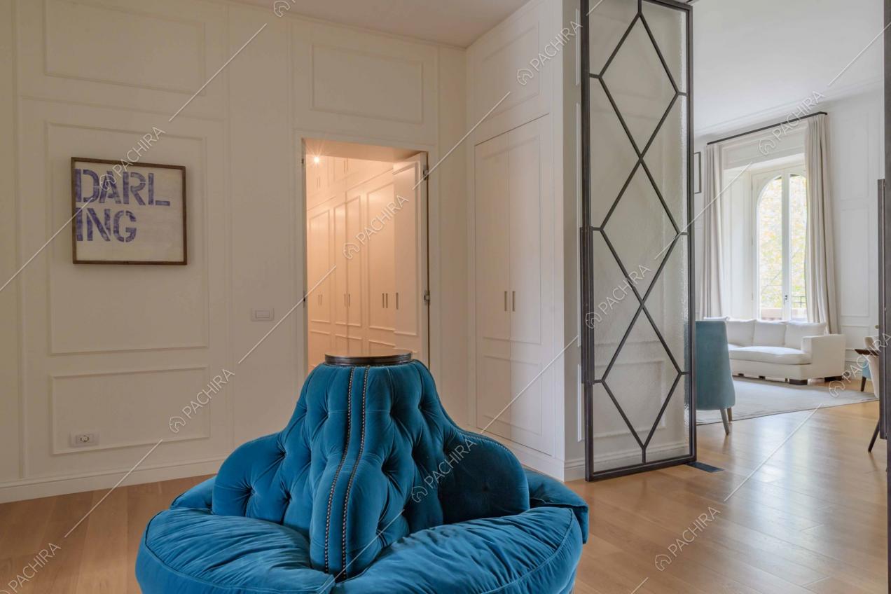 Nell'atrio della location pareti bianche con boiserie e poltrona di velluto blu