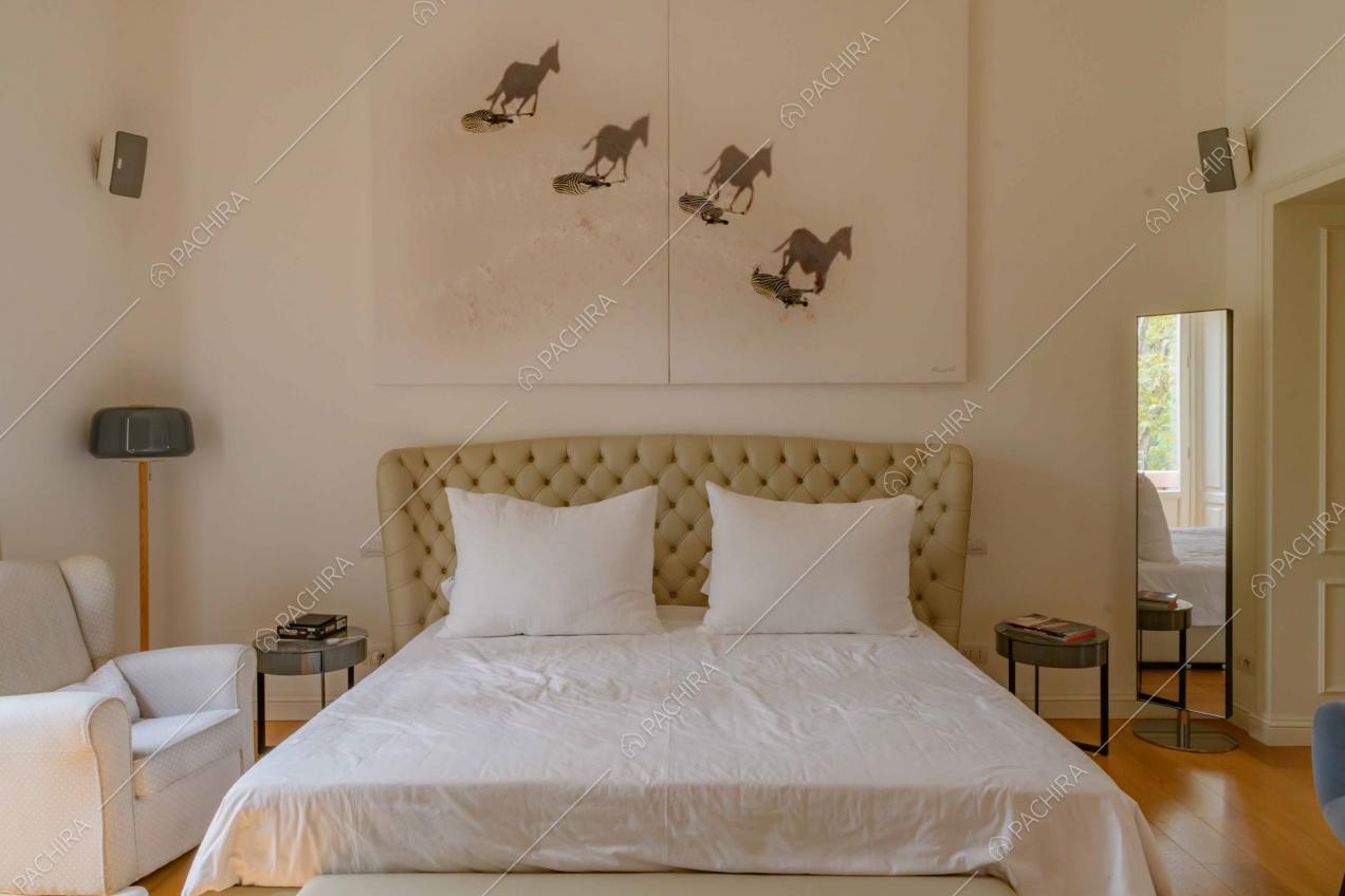 Pareti bianche e pavimento in parquet nella camera da letto matrimoniale