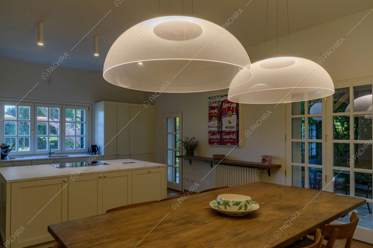 Lampadari di design sul tavolo da pranzo in legno della cucina a vista e a isola